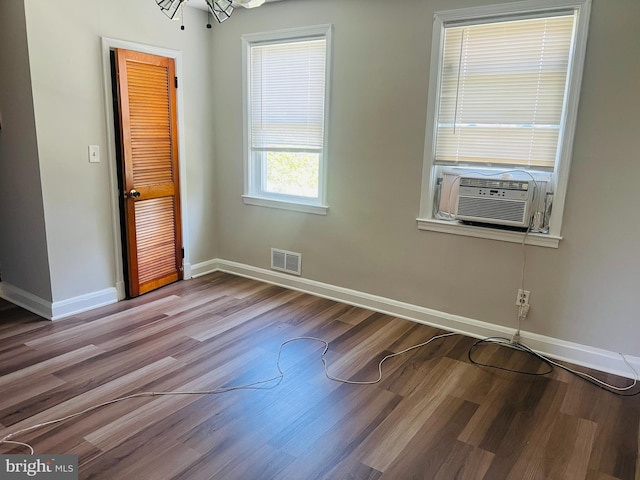 spare room with hardwood / wood-style floors, cooling unit, and a notable chandelier