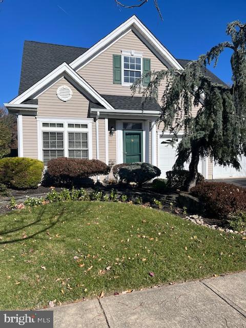 front of property with a garage and a front lawn