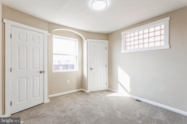 unfurnished bedroom featuring light carpet