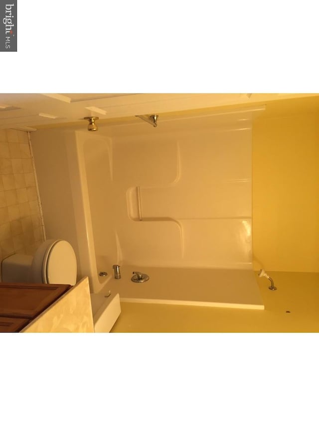 bathroom featuring shower / bathing tub combination and toilet