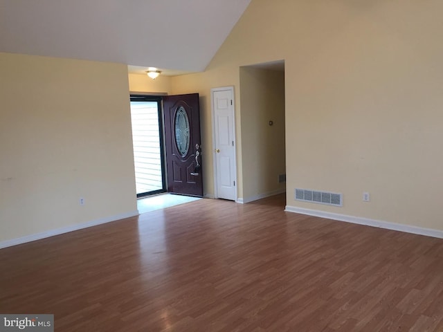 foyer with hardwood / wood-style floors and high vaulted ceiling