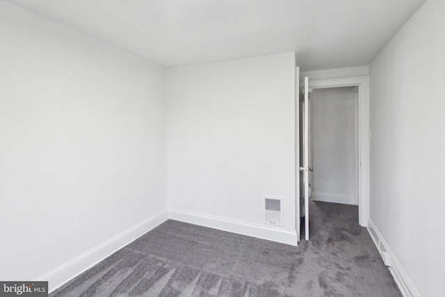 empty room featuring dark colored carpet