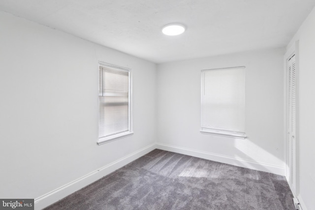 unfurnished room with dark colored carpet