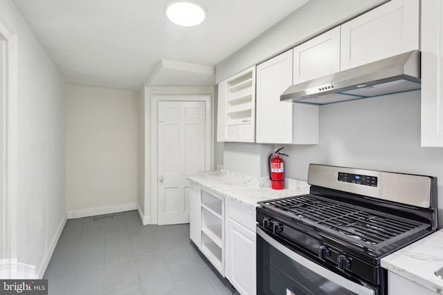 kitchen with light stone countertops, stainless steel gas stove, white cabinets, and extractor fan