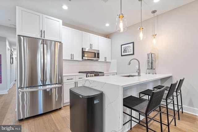 kitchen with appliances with stainless steel finishes, white cabinetry, and sink