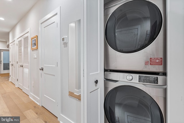 washroom with light wood-type flooring and stacked washer / dryer