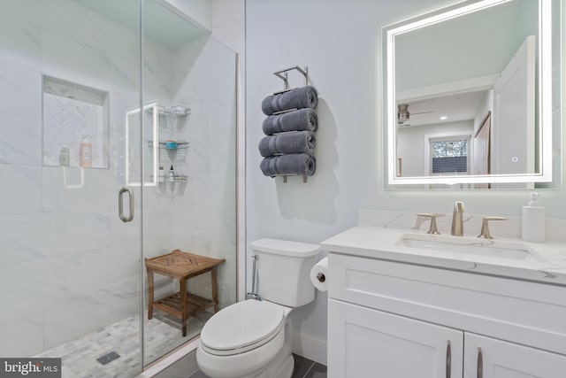 bathroom featuring ceiling fan, toilet, vanity, and walk in shower