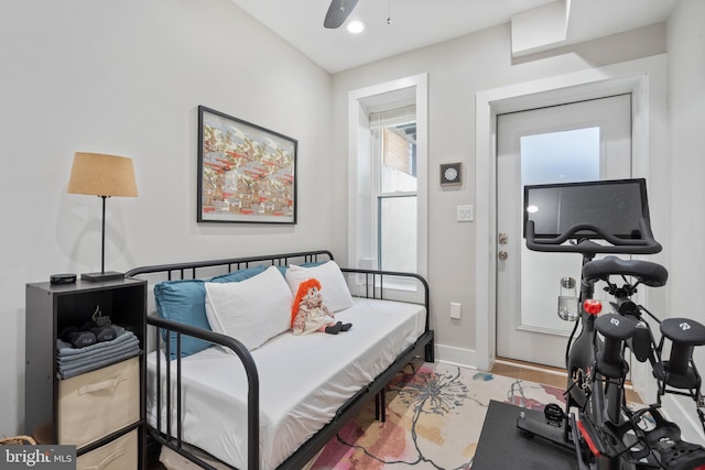 bedroom featuring ceiling fan, light hardwood / wood-style floors, and multiple windows