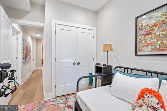 bedroom with light hardwood / wood-style floors and a closet