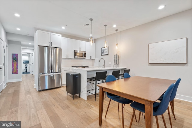 dining room with light wood-type flooring and sink