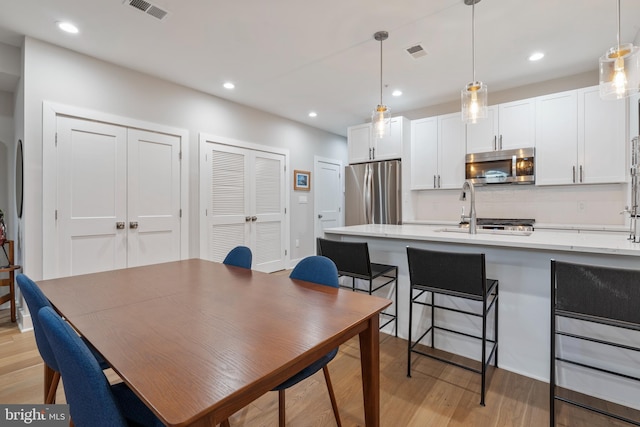 dining room with light hardwood / wood-style flooring and sink