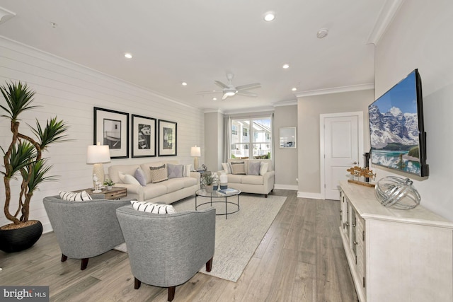 living room featuring wood-type flooring, ceiling fan, ornamental molding, and wood walls