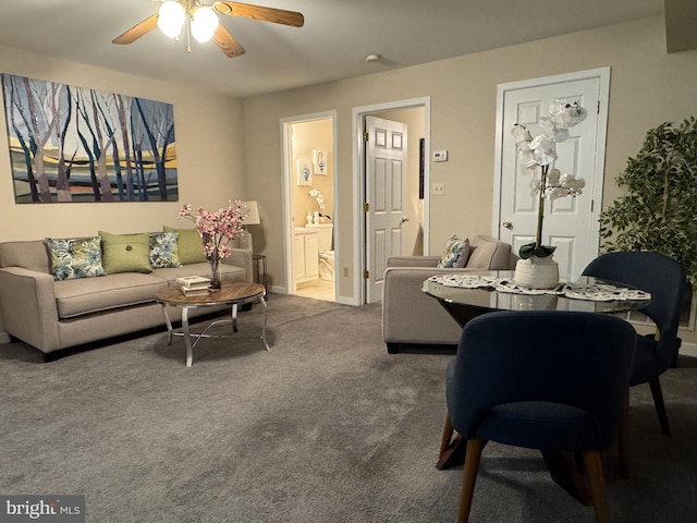 living area with ceiling fan, carpet, and baseboards