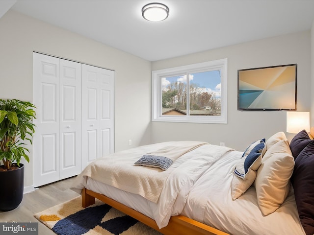 bedroom with light wood-type flooring and a closet