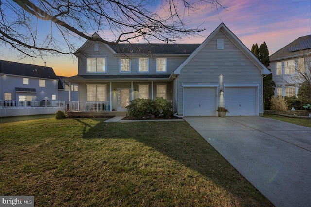 view of front of home with a lawn, a porch, and a garage