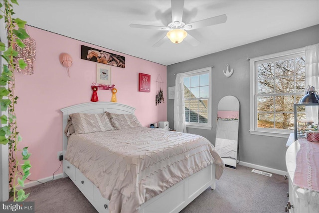 carpeted bedroom with ceiling fan and multiple windows