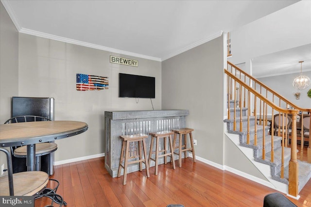 living room with a chandelier, hardwood / wood-style flooring, and ornamental molding