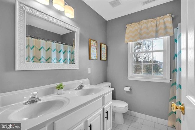 bathroom with tile patterned flooring, vanity, and toilet