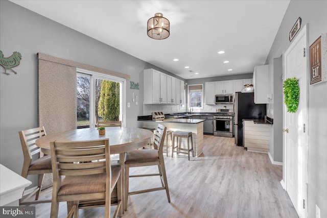 dining room with a healthy amount of sunlight, light wood-type flooring, and sink