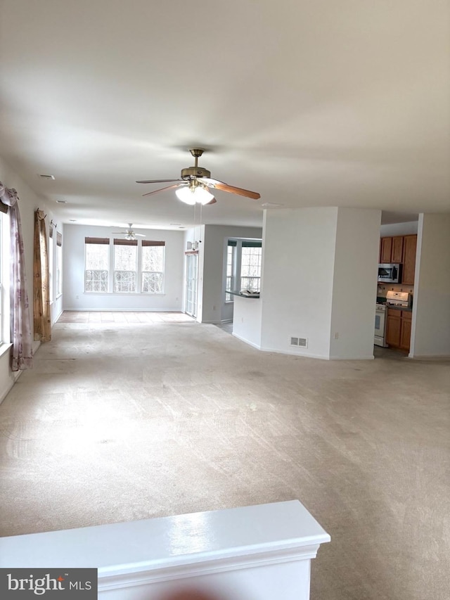 unfurnished living room with ceiling fan and light colored carpet