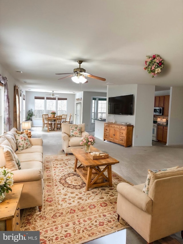 living room with light carpet and ceiling fan