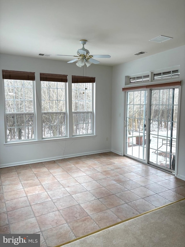 unfurnished room with light tile patterned floors and ceiling fan