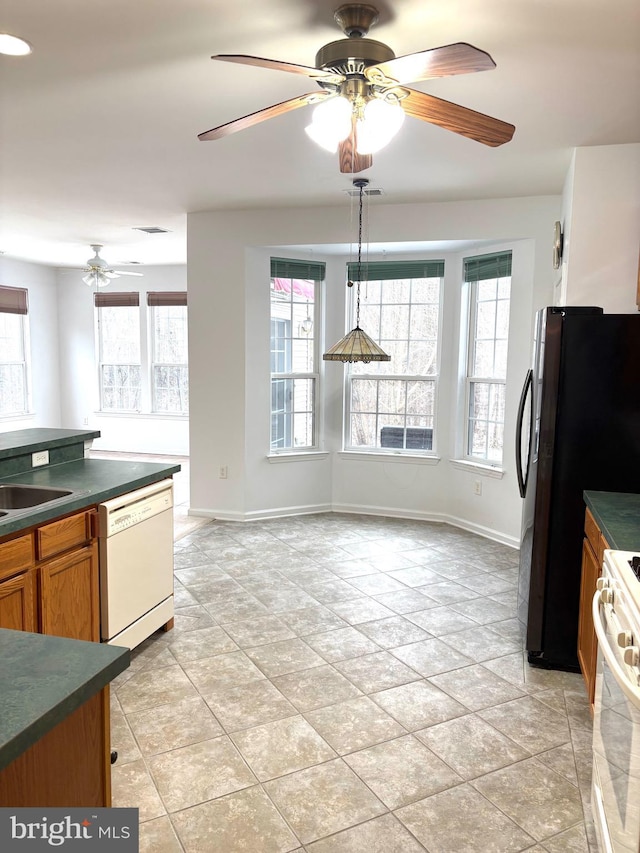 kitchen with white appliances, decorative light fixtures, ceiling fan, and sink