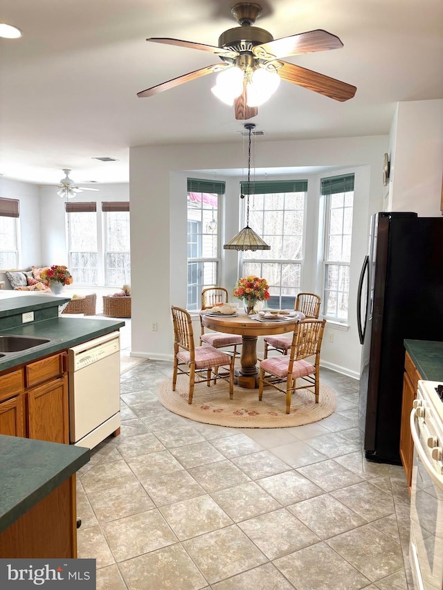 kitchen featuring pendant lighting, a healthy amount of sunlight, white appliances, and sink