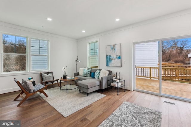 living room featuring light hardwood / wood-style floors and ornamental molding