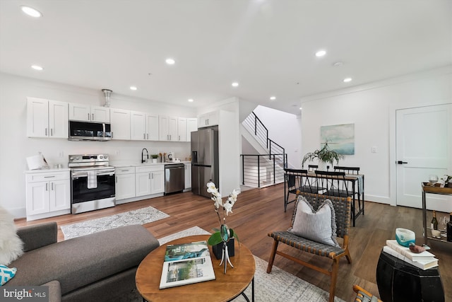 living room featuring crown molding, dark wood-type flooring, and sink