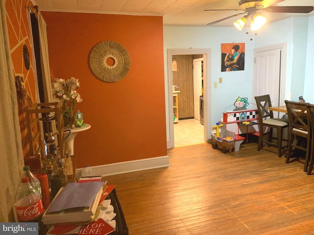 interior space featuring light wood-type flooring, ceiling fan, and crown molding