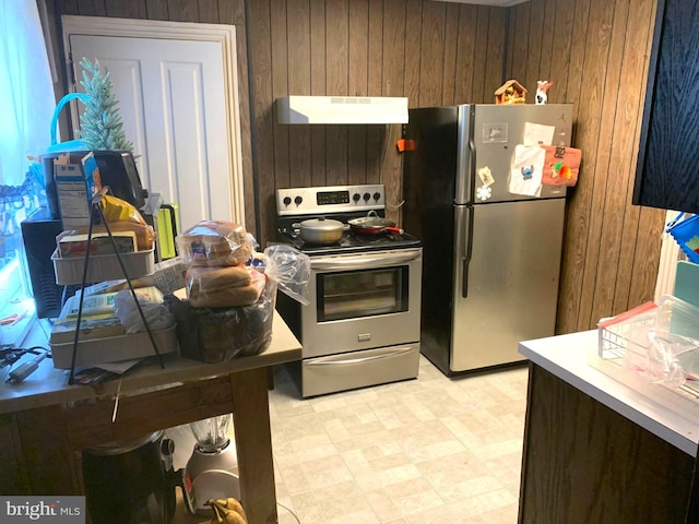 kitchen with appliances with stainless steel finishes and wooden walls