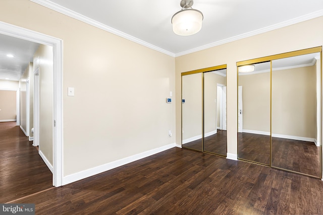 unfurnished bedroom with two closets, dark hardwood / wood-style floors, and crown molding