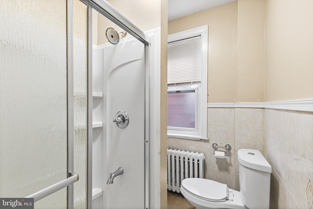 bathroom with walk in shower, toilet, radiator, and tile walls