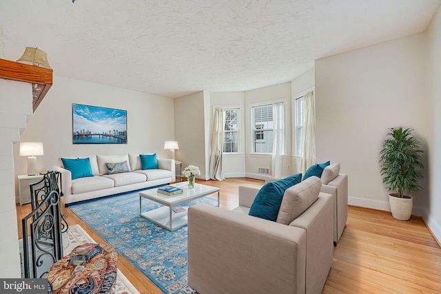 living room with a textured ceiling and light wood-type flooring