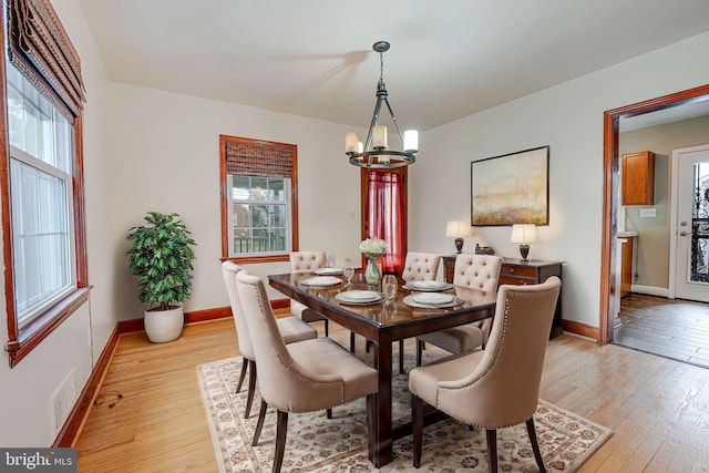 dining room featuring light hardwood / wood-style floors, a wealth of natural light, and a chandelier