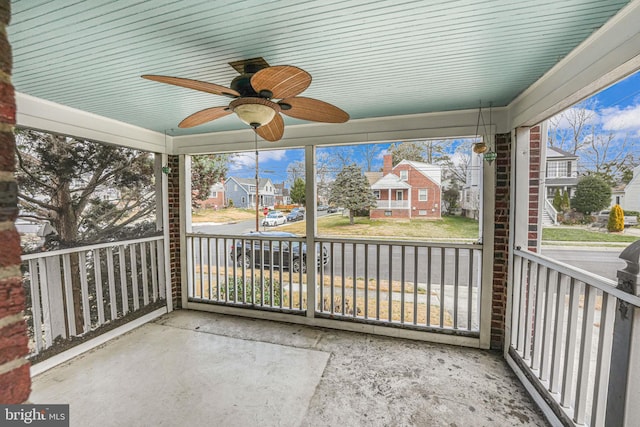 unfurnished sunroom with ceiling fan