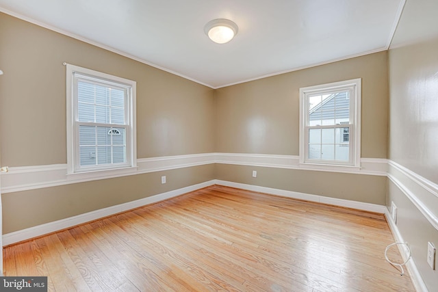 spare room with light hardwood / wood-style floors and crown molding