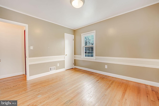 unfurnished room with light wood-type flooring and crown molding