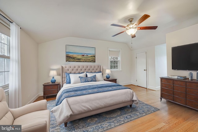 bedroom with multiple windows, light wood-type flooring, vaulted ceiling, and ceiling fan