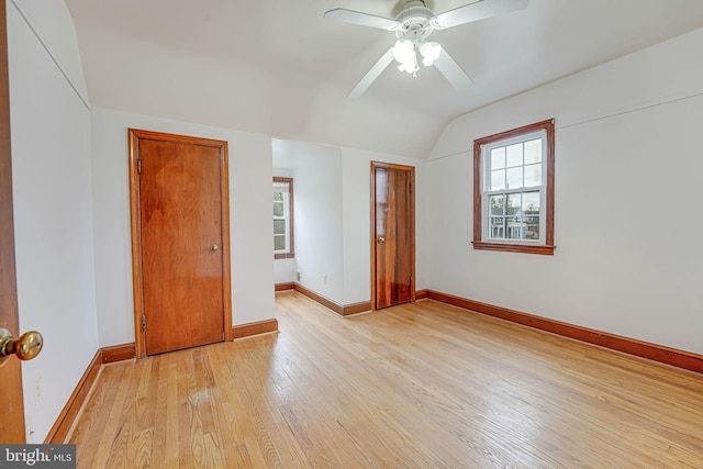 unfurnished bedroom with ceiling fan, vaulted ceiling, and light wood-type flooring