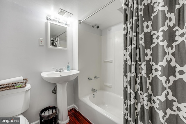 full bathroom featuring sink, shower / tub combo, and toilet