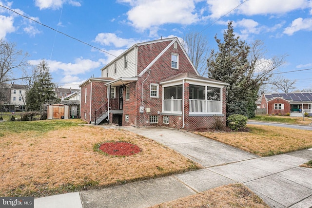 view of front of house featuring a front yard and a shed