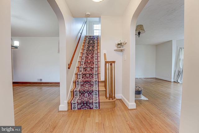 stairs featuring hardwood / wood-style floors