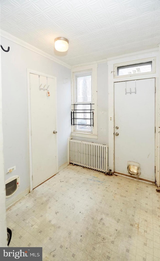 foyer entrance with radiator heating unit and crown molding