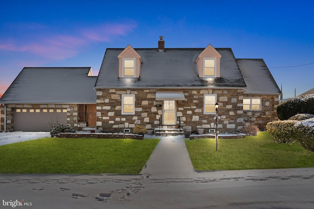 view of front of home featuring a garage and a lawn