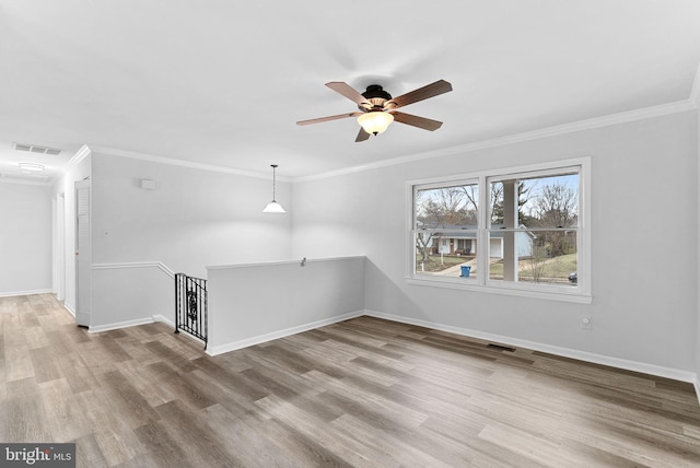 unfurnished living room featuring ceiling fan, ornamental molding, and wood-type flooring