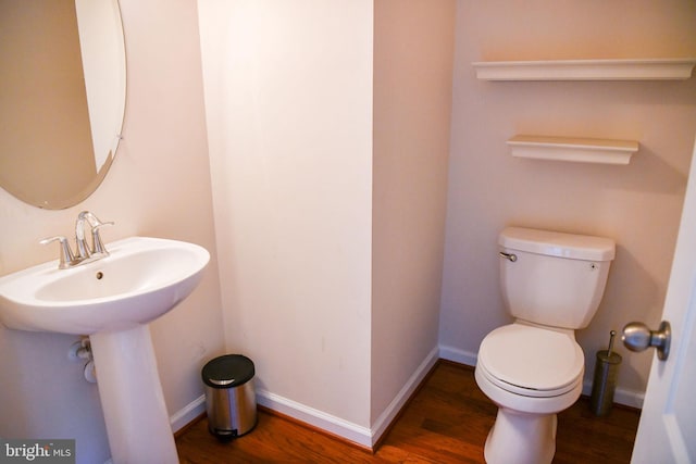 bathroom with hardwood / wood-style flooring and toilet