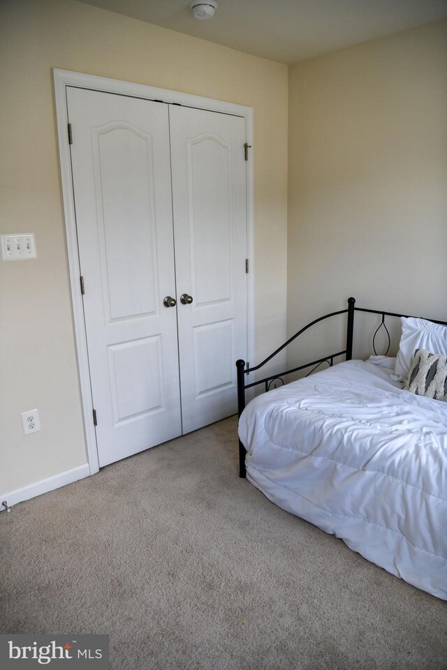 bedroom featuring light carpet and a closet