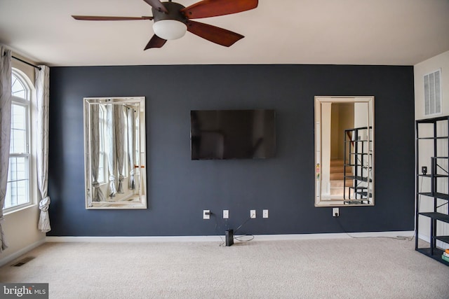 unfurnished living room featuring ceiling fan and light carpet